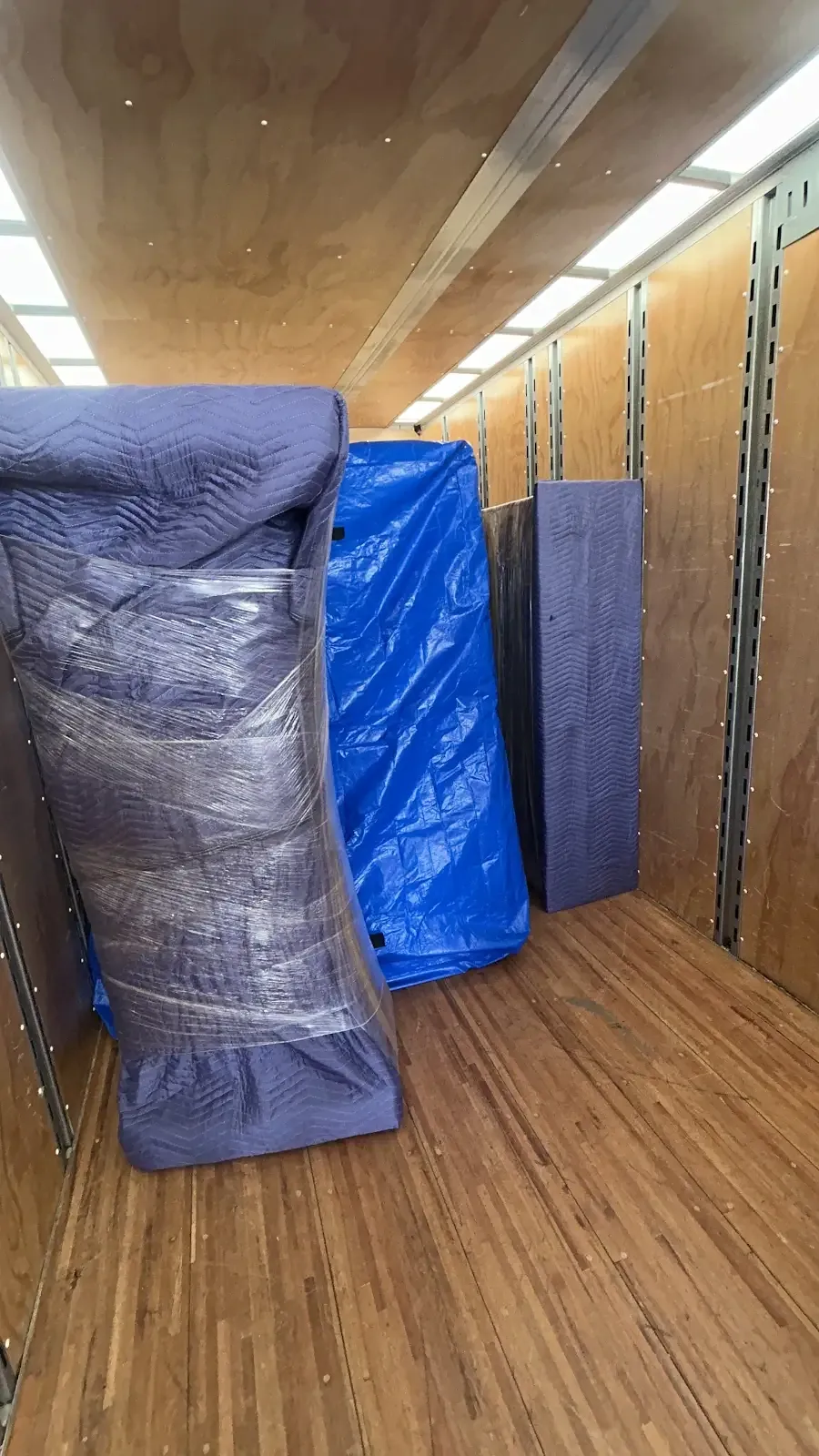 Furniture protected with moving blankets inside a trailer